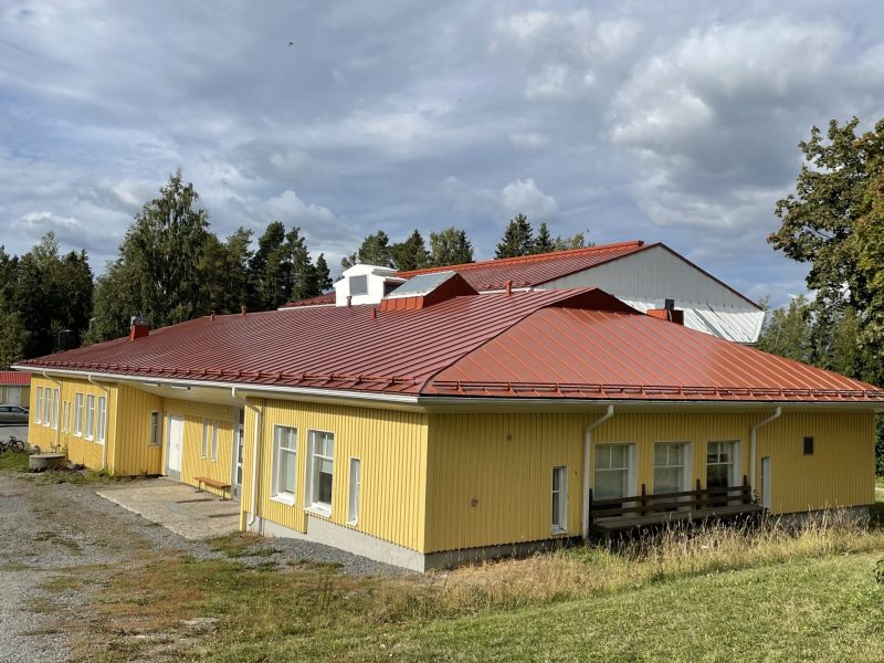 Suuri punatiilikattoinen puurakennus maalattu keltaiseksi - Taloyhtiön maalaus Värixi